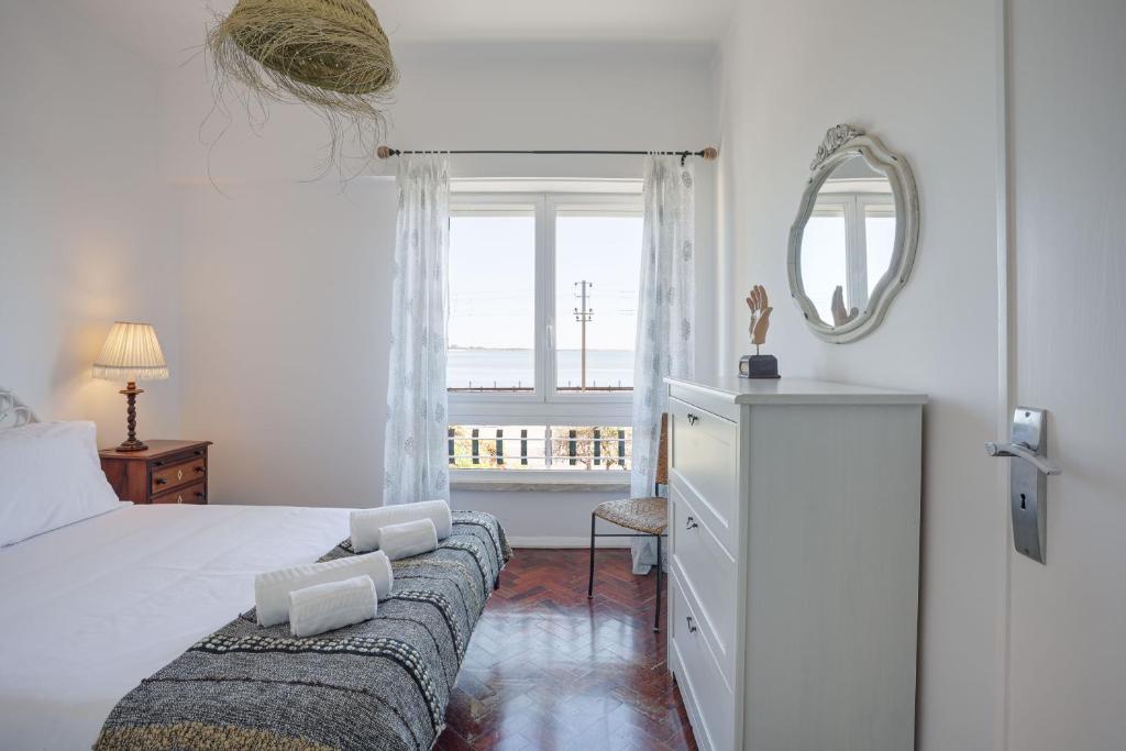 - une chambre avec un lit, un miroir et une fenêtre dans l'établissement Charming TM Flat by the Ocean with a View, à Cruz Quebrada