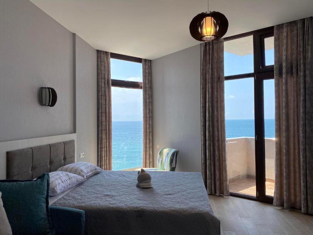 a bedroom with a bed and a view of the ocean at Gonio Seaside Residence in Gonio