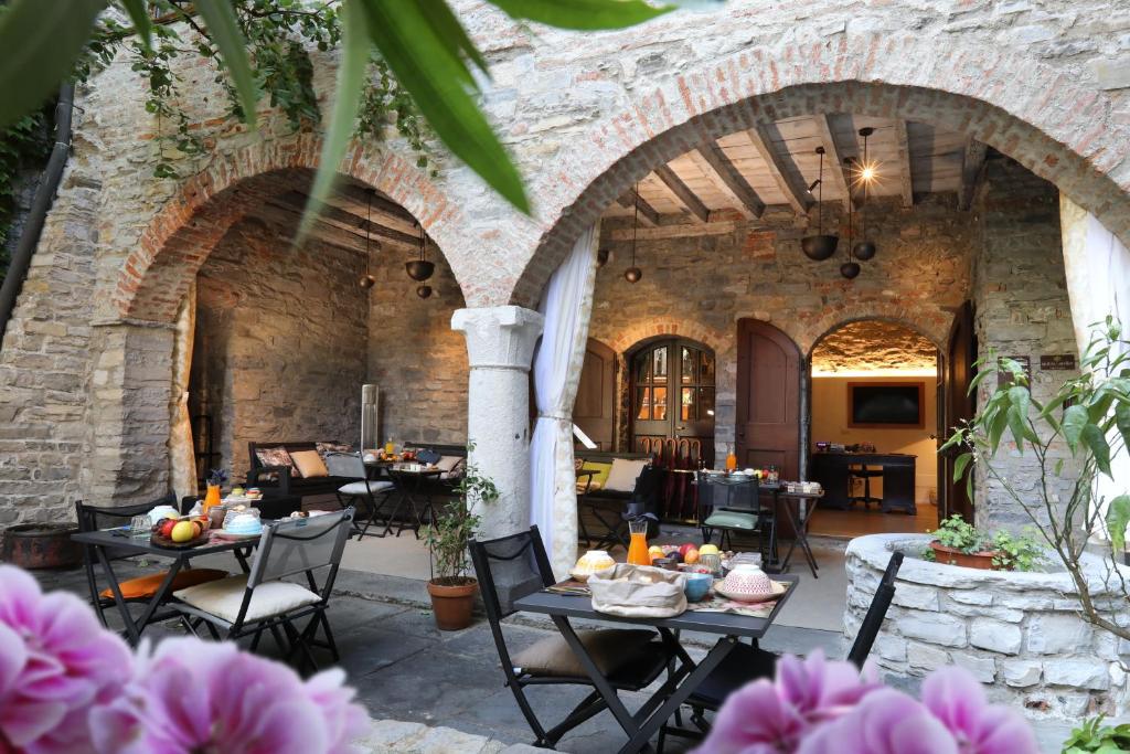 a patio with tables and chairs in an old building at Suites&Atelier Lake Como in Como