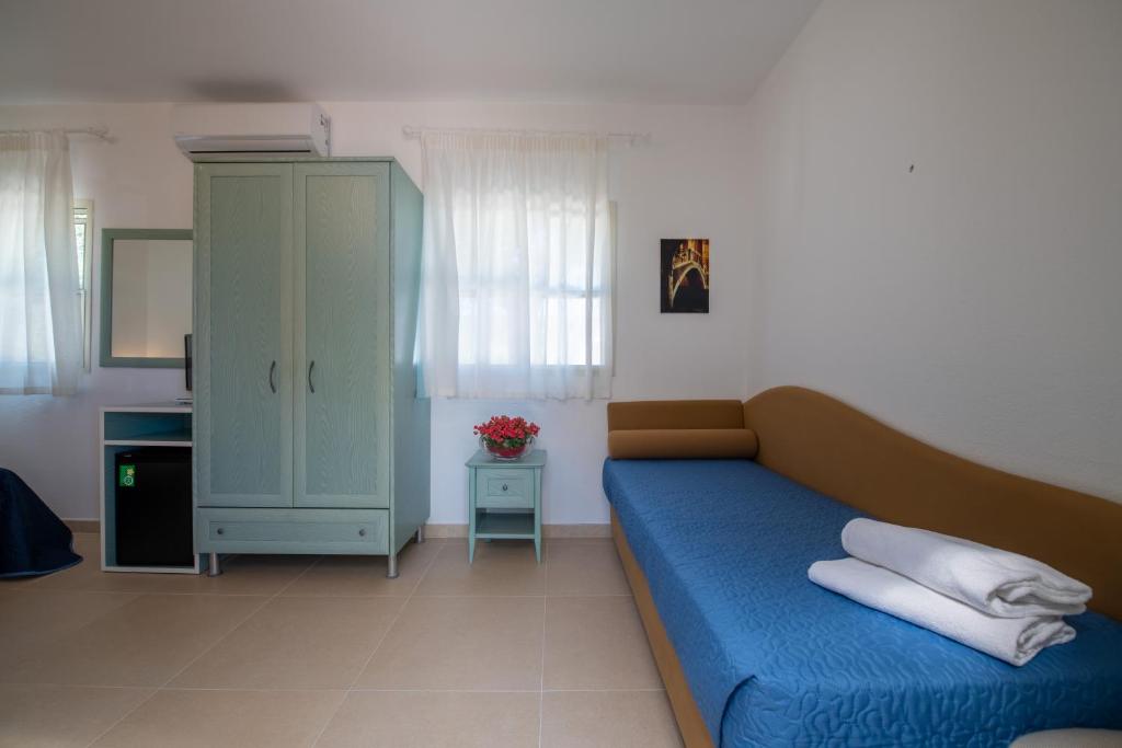 un soggiorno con divano blu e armadio di Albergo Villa A Mare a Peschici