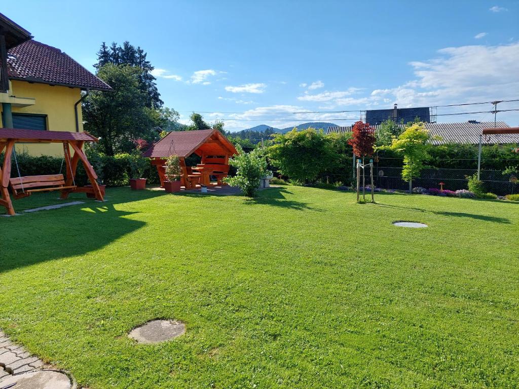 un gran patio con un parque infantil y una casa en Ferienwohnung Liskowetz en Lambichl