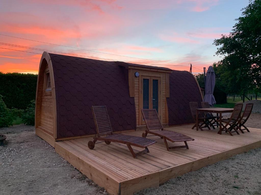 een hut met een tafel en stoelen op een terras bij Le charmant Pod du Parolais in Beauvoisin