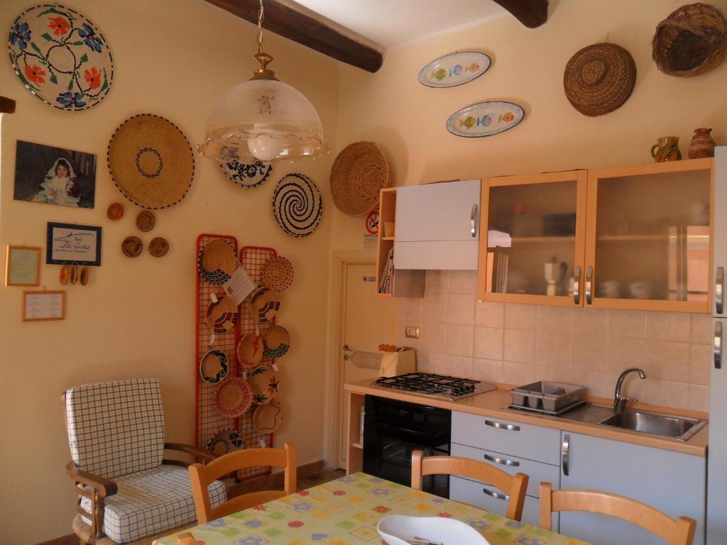 una cucina con tavolo e piano cottura forno superiore di Sa Domo de Minnanna a Castelsardo