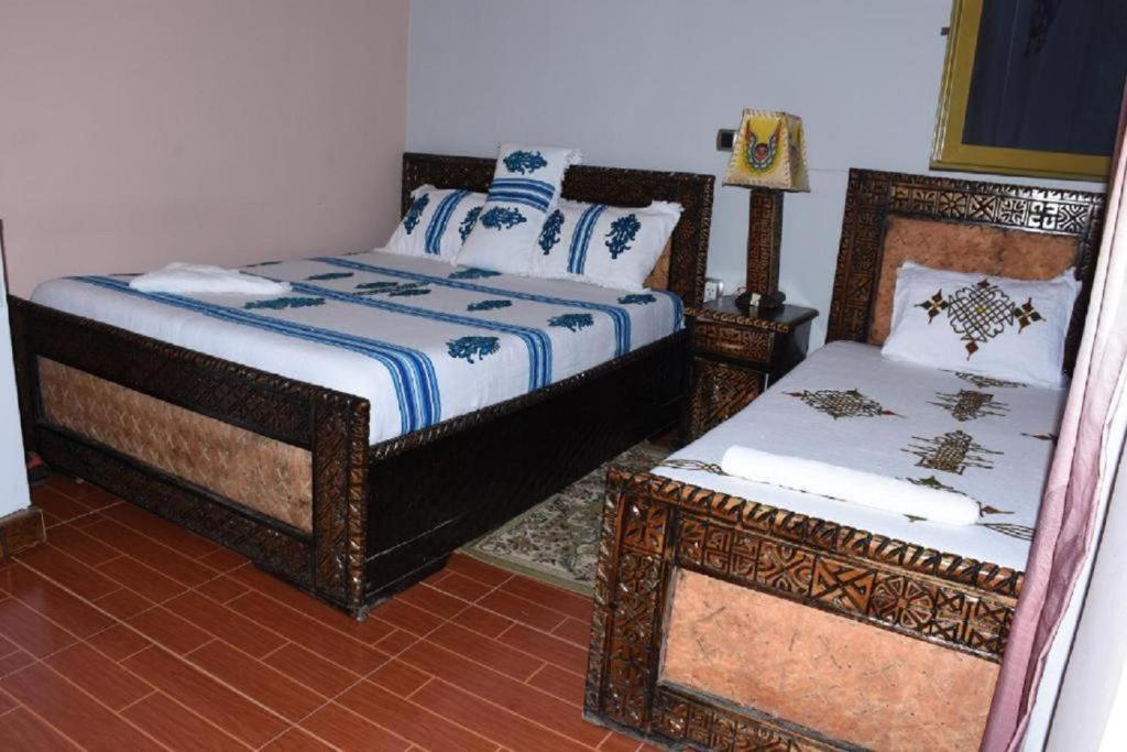 a bedroom with two beds and a table and a bedskirtspectspectspectspects at Blue Nile Guest House in Lalibela