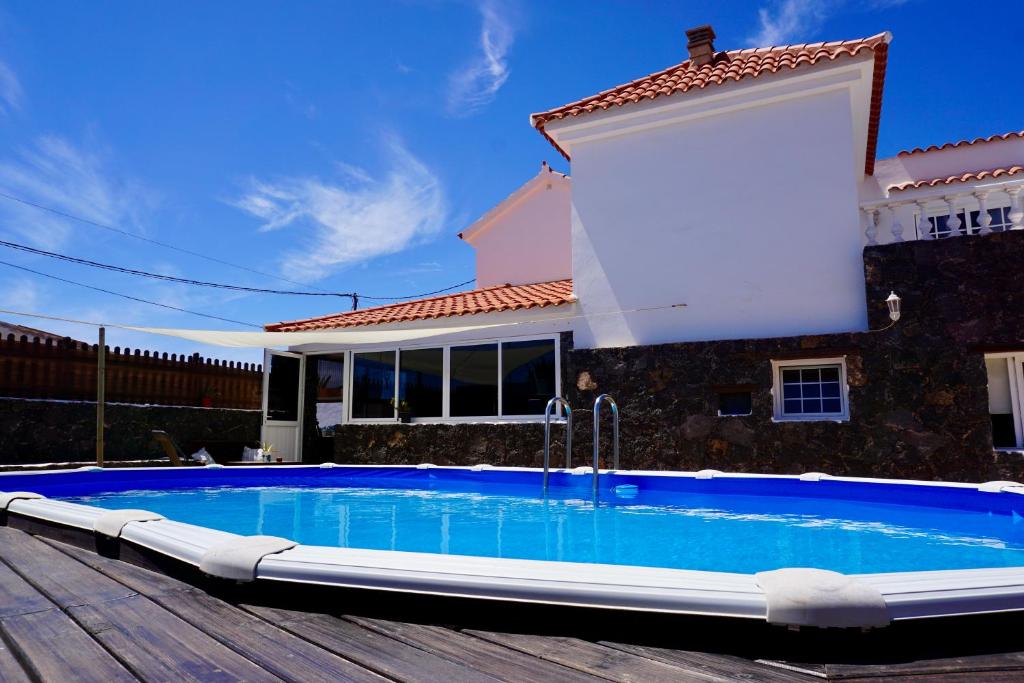 a swimming pool in front of a house at Casa Natura Ainhoa in La Oliva