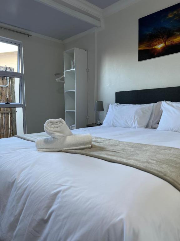a white bed with a towel on top of it at Bella Lux Holiday Condos in Durban