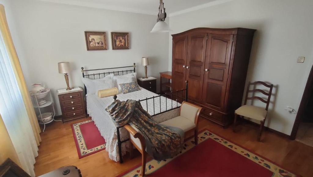 ヴィラ・ノーヴァ・デ・セルヴェイラにあるCasa do Artesanatoのベッドルーム1室(ベッド1台、椅子1脚、キャビネット付)