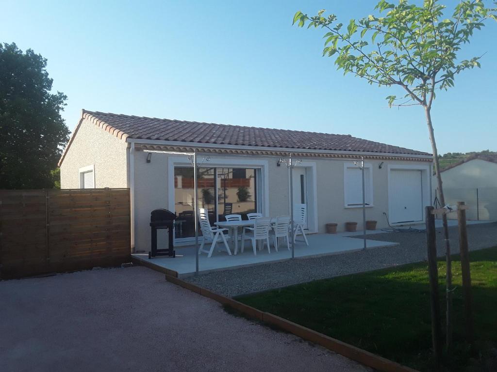 uma casa com um pátio com uma mesa e cadeiras em Maison individuelle neuve avec piscine em Limoux