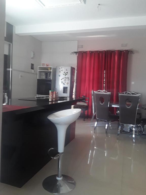 a kitchen with a black counter and a red curtain at Unik studio Apartments in Lusaka