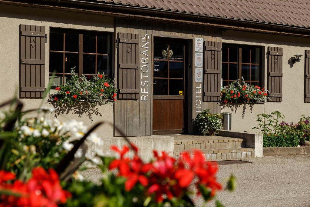 a building with flowers in front of a door at Pļavas in Ainaži