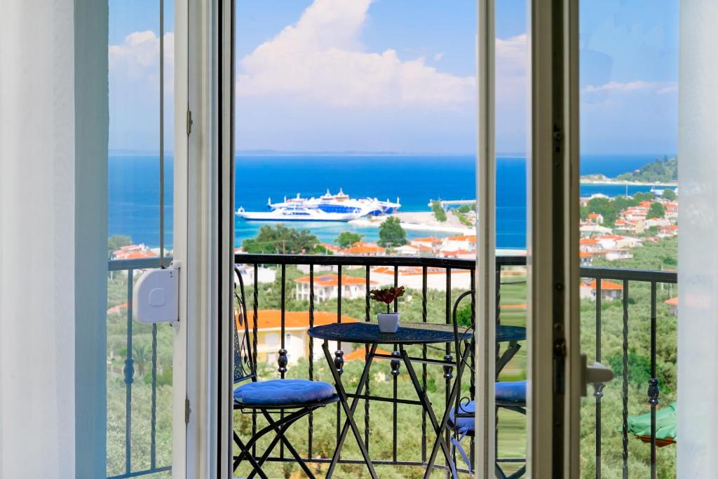 balcón con mesa y vistas al océano en Villa Valia Calda, en Limenas