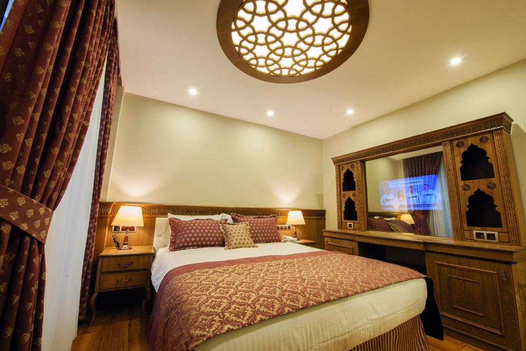 1 dormitorio con 1 cama y TV en Hotel Ney, en Konya