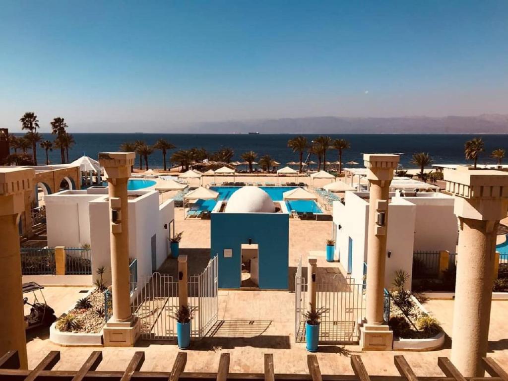 a view of a resort with palm trees and the ocean at Sea View Apartment at Tala Bay Resort in Aqaba in Aqaba