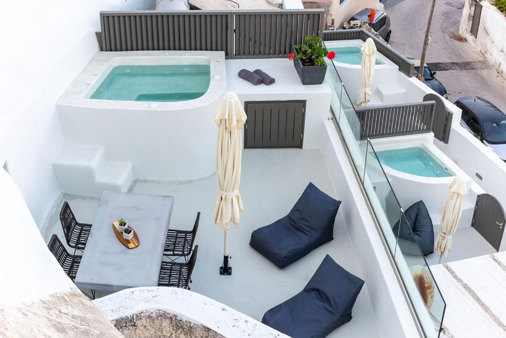 een boot met 2 hot tubs en stoelen op het terras bij Afora Houses in Vóthon