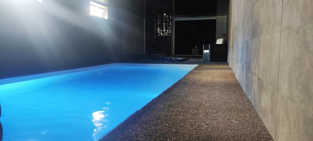 - une piscine avec éclairage bleu dans un bâtiment dans l'établissement Suite avec piscine privée, à Chelles