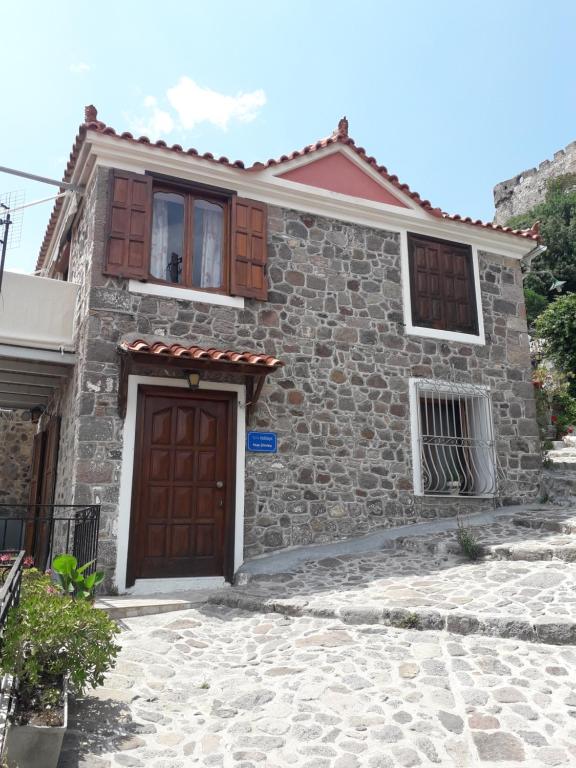 a small stone house with a brown door at Dimitra House in Mithymna