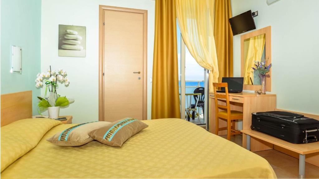 Schlafzimmer mit einem Bett und einem Schreibtisch mit einem Computer in der Unterkunft Hotel Caggiari in Senigallia
