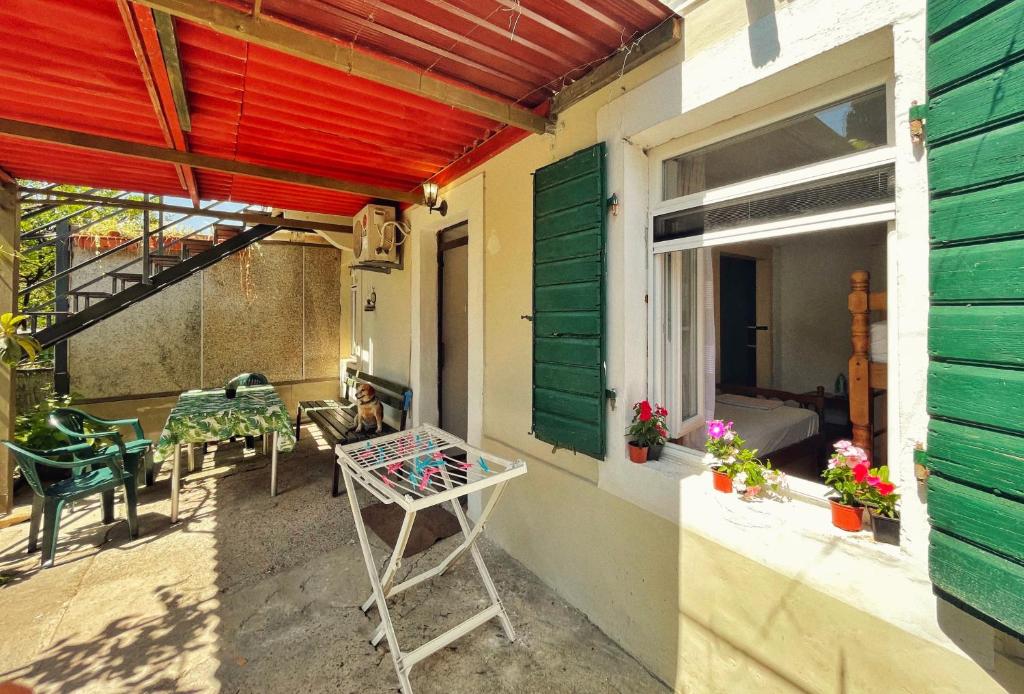 an outdoor patio with a table and a window at 1-bedroom apartment with 3 beds + private parking in Tivat