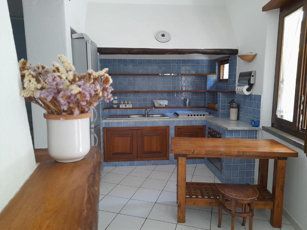 una cocina con una mesa y un jarrón de flores en Casa Mandarino Forio Ischia en Ischia