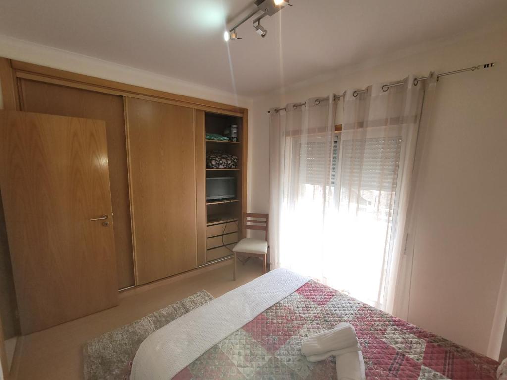 a bedroom with a bed and a window at Alojamento Valverde in Nazaré