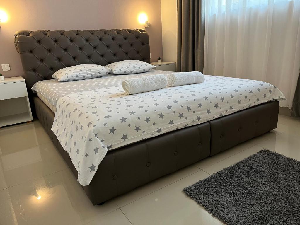 una camera con un grande letto con testiera in pelle di Apartman Mijailović 3 a Soko Banja