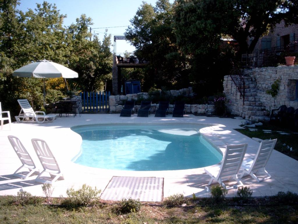 une piscine avec des chaises et un parasol dans l'établissement PROVENCE SOLEIL LUBERON PISCINE, à Apt