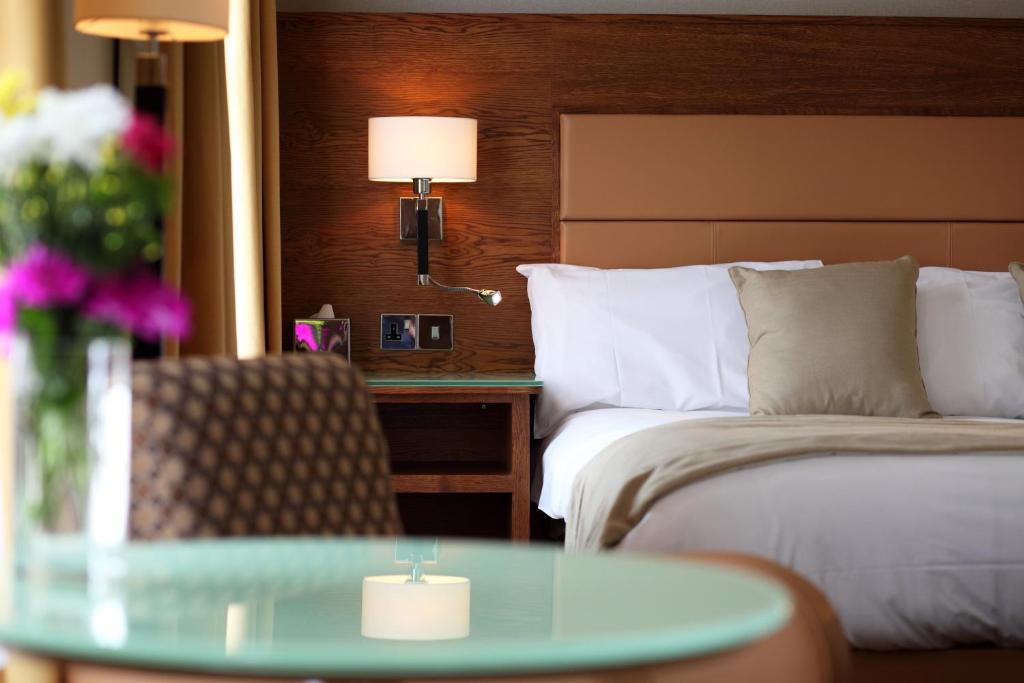 Habitación de hotel con cama y mesa de cristal en Prom Hotel en Great Yarmouth