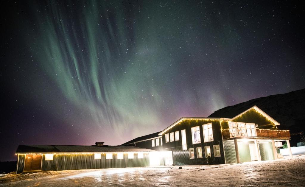 budynek z zorzą polarną na niebie w obiekcie Farmhotel Efstidalur w mieście Laugarvatn
