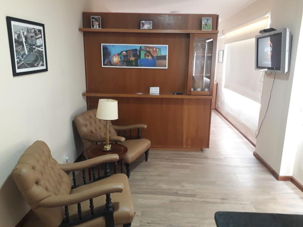 a living room with two chairs and a tv at 4 Ventanales sobre la Avenida Corrientes in Buenos Aires