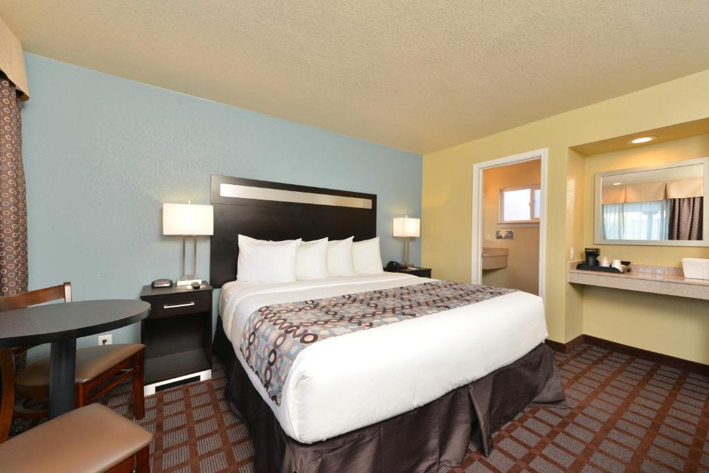 a hotel room with a large bed and a table at Avenue Inn Downtown San Luis Obispo in San Luis Obispo