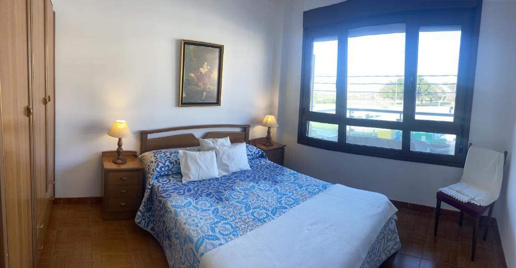 um quarto com uma cama azul e branca e uma janela em Noja Ris - 6039 em Noja