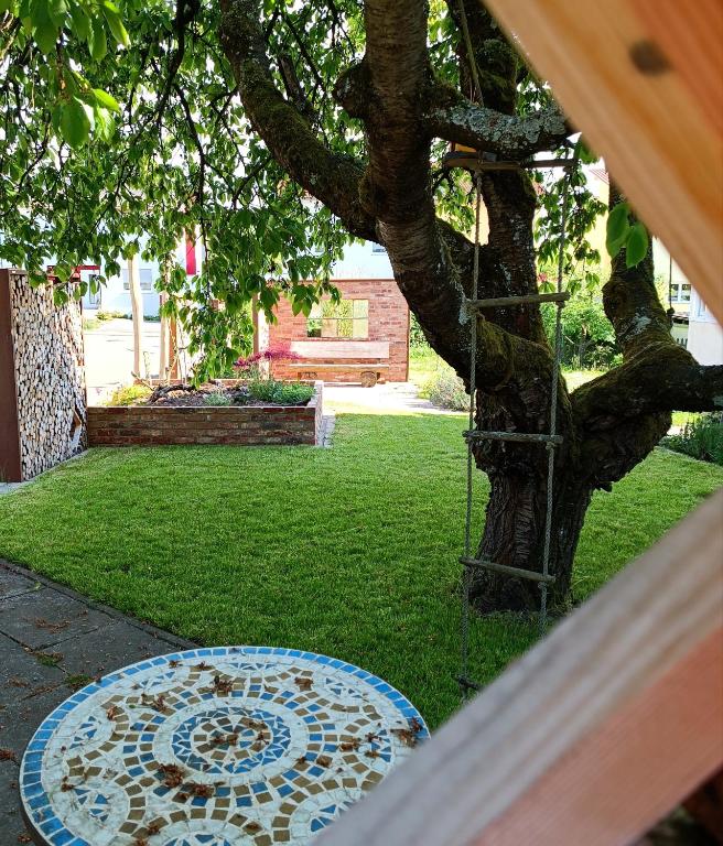 a garden with a mosaic table next to a tree at Casa del Norte in Brackenheim