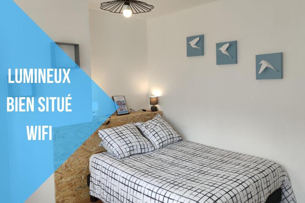 uma cama num quarto com um azul e branco em Les lumières du phare em Calais