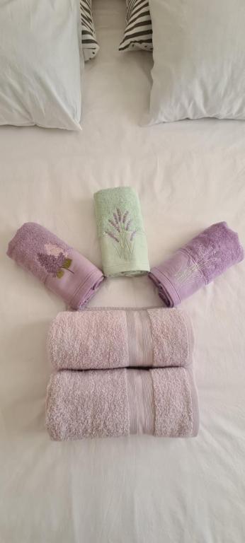 a group of three towels on a bed at Lavanda in Vrana