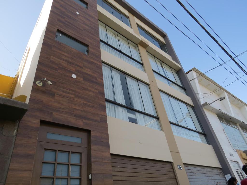 a building with a brown and white facade at Casa Las Flores Ica in Ica