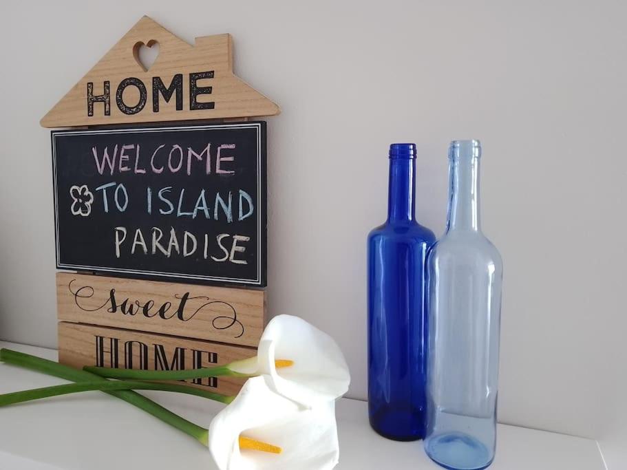 a welcome to island paradise sign and a blue bottle at Apartamento Humboldt ,Island Paradise in La Orotava
