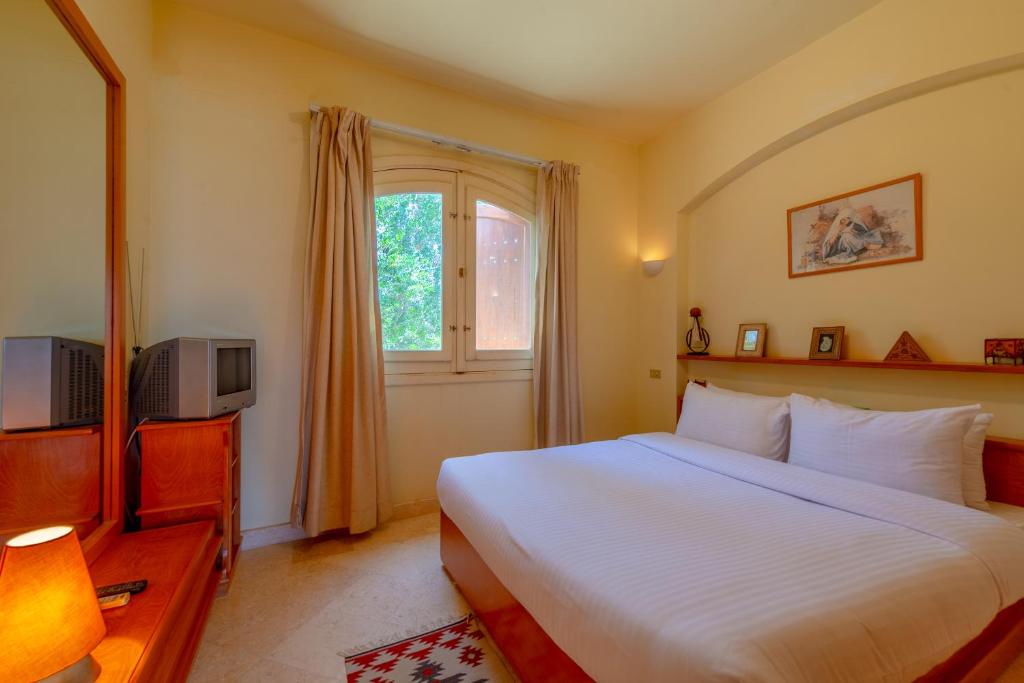 a bedroom with a white bed and a window at VESTA - El Gouna Residence in Hurghada