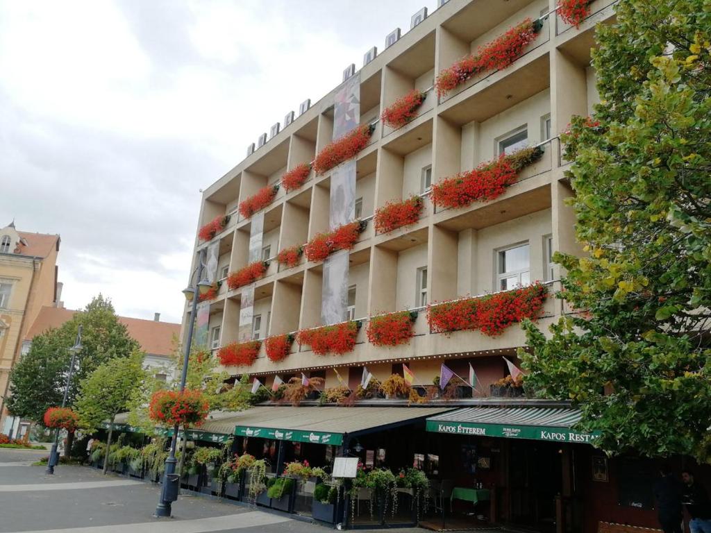 un grand bâtiment avec des fleurs sur son côté dans l'établissement Hotel Kapos, à Kaposvár