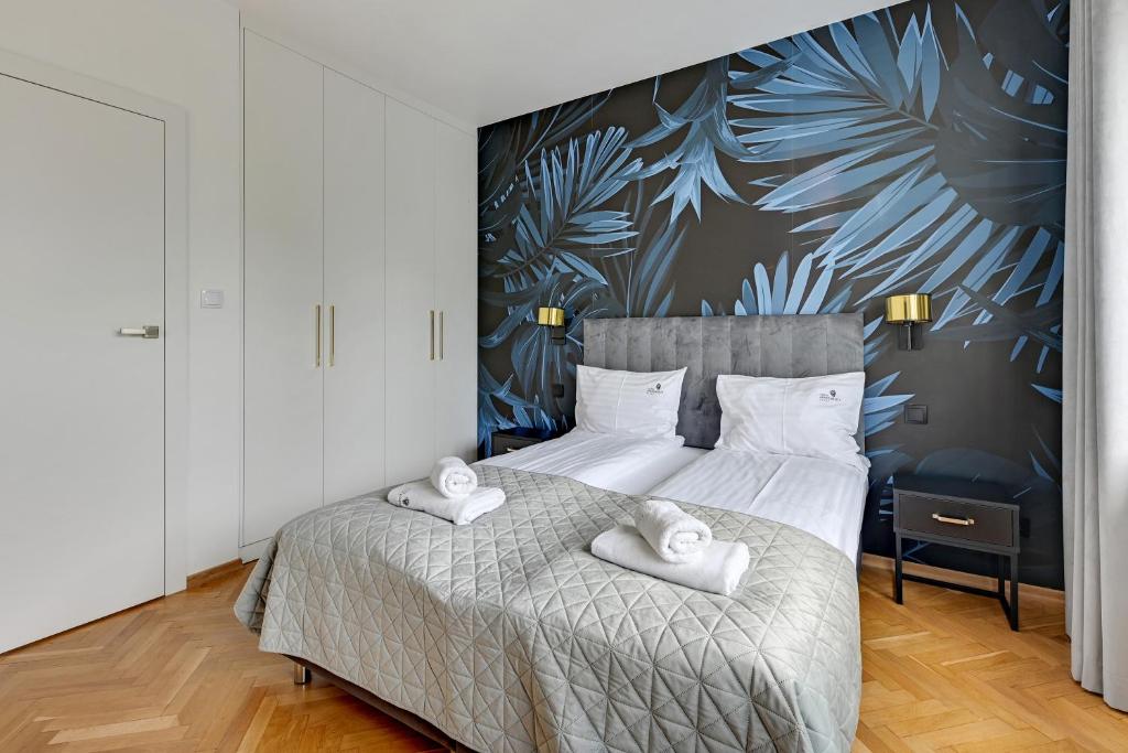 a bedroom with a bed with two towels on it at Lion Apartments - Rio close to the beach and Monte Cassino in Sopot