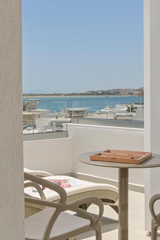 a table and chairs on a balcony with a view of the water at Elite Suites Naxos in Naxos Chora
