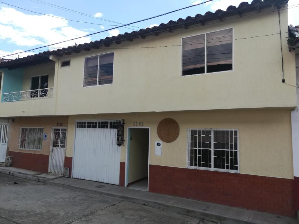 Casa blanca con puerta y ventanas en HOSTAL HELICONIAS, en Charalá