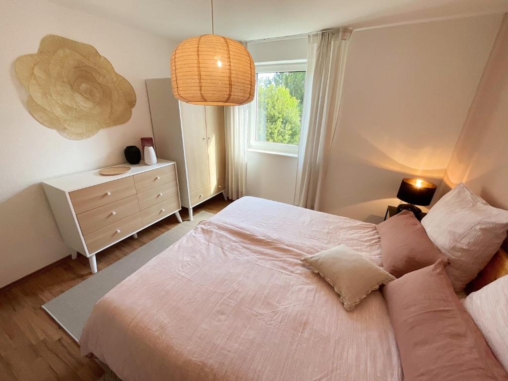 1 dormitorio con cama y ventana en Ferienwohnung Ptit Monde, en Friedrichshafen