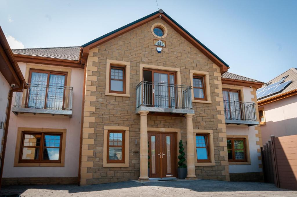 ein großes Backsteinhaus mit einer Uhr drauf in der Unterkunft St Martins House Apartments in Tranent