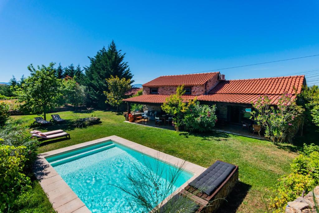 a backyard with a swimming pool and a house at Quinta da Pereira in Armamar