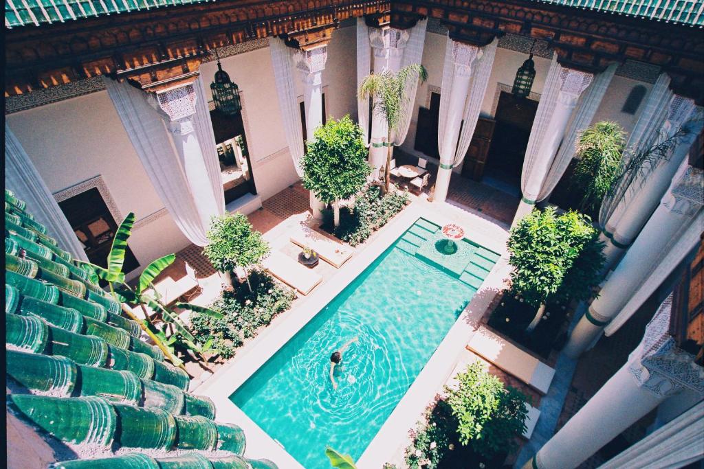 an overhead view of a swimming pool with plants at Riad Slitine & Spa in Marrakesh