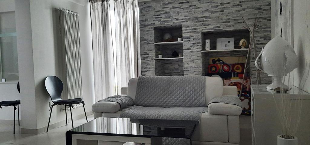 uma sala de estar com um sofá e uma parede de tijolos em Casa Margherita em Noci