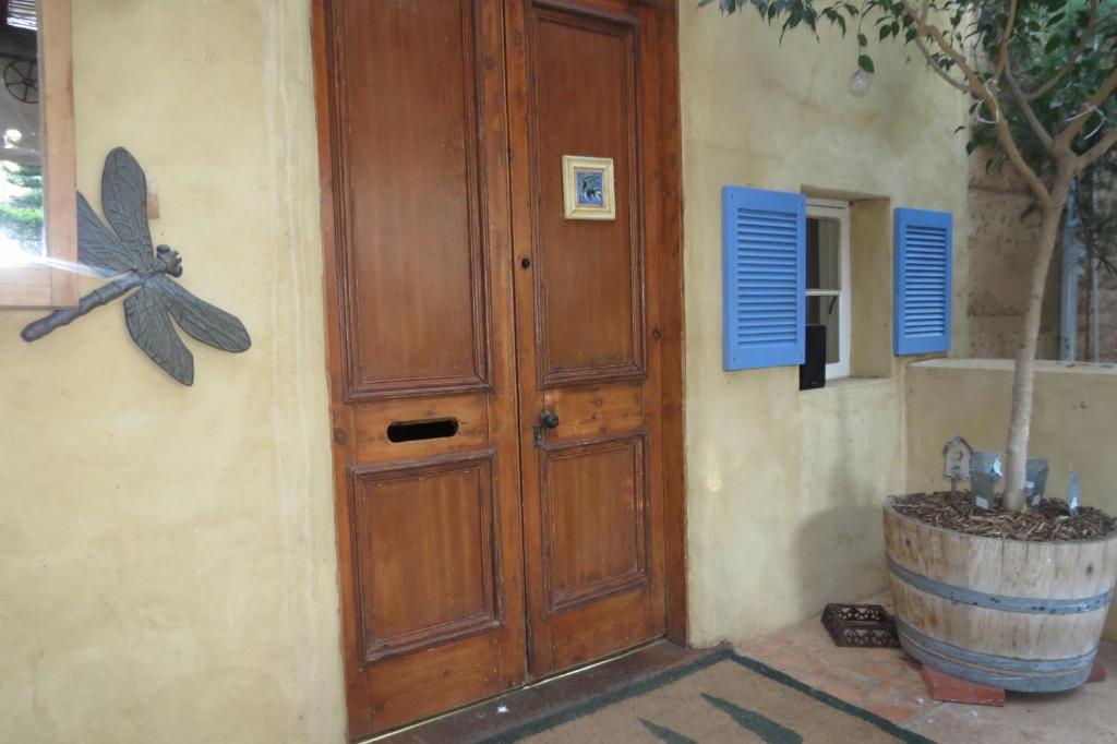 a wooden door with a butterfly on the side of a building at Bentwood Olive Grove Accommodation in Greenough