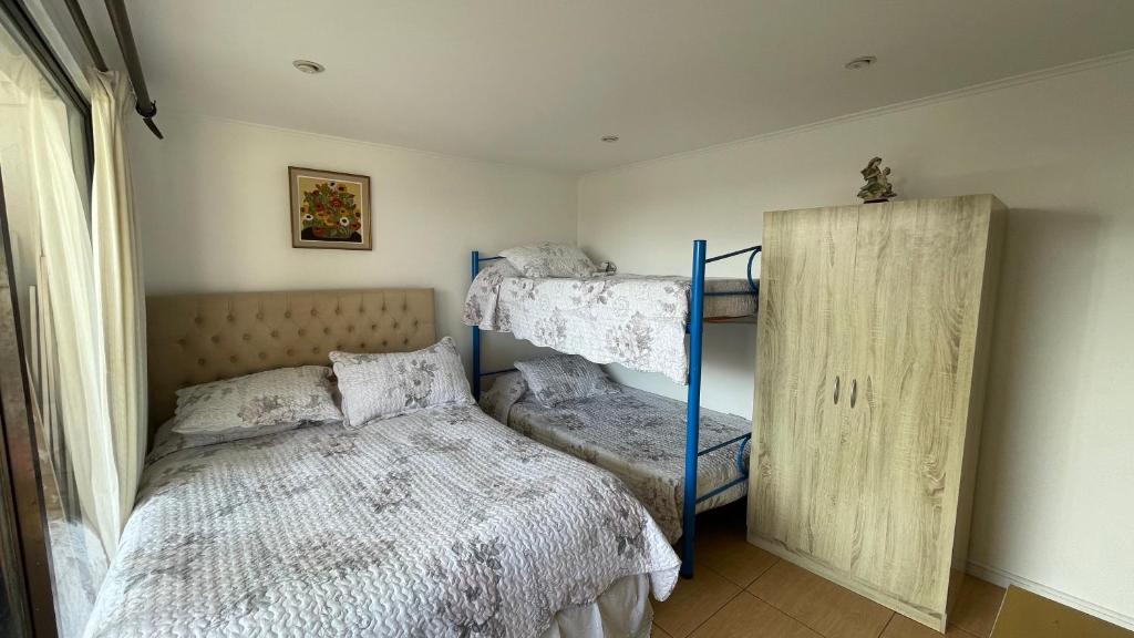 a bedroom with two bunk beds and a window at Calor De Hogar La Serena in La Serena