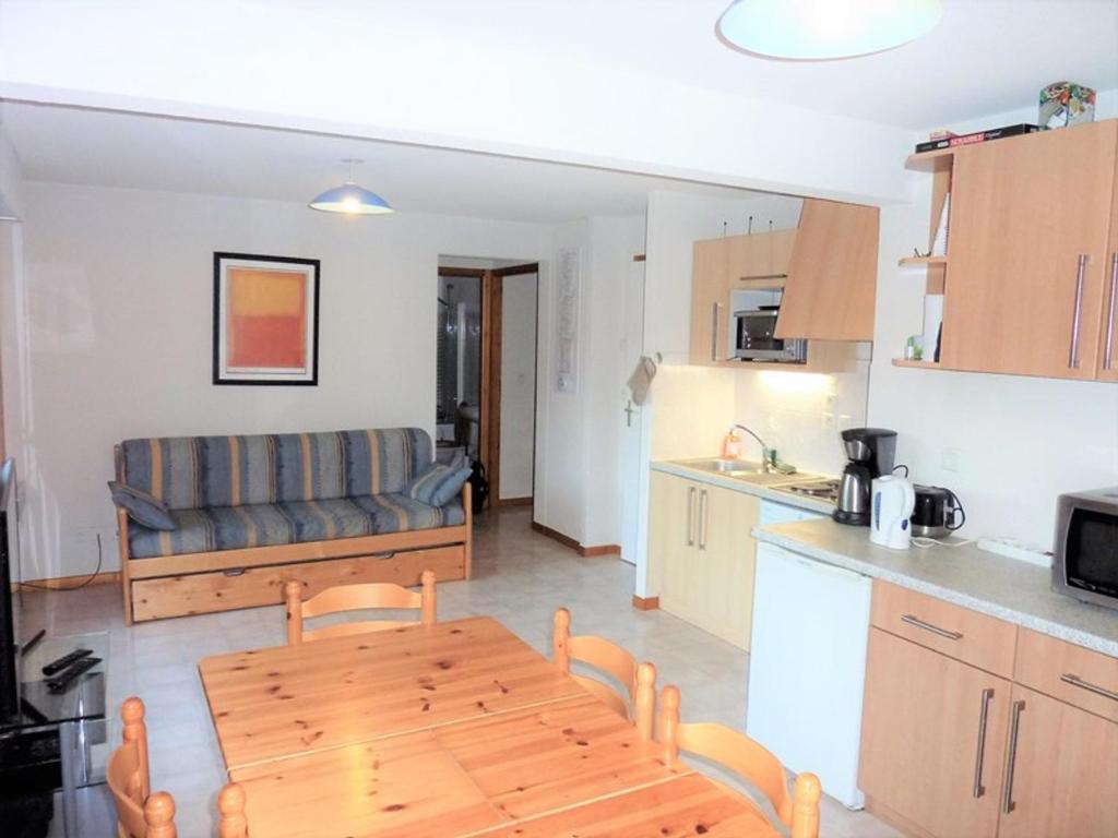 a kitchen and a living room with a table and a couch at Appartement Saint-Jean-d'Aulps, 3 pièces, 6 personnes - FR-1-573-105 in Saint-Jean-d'Aulps