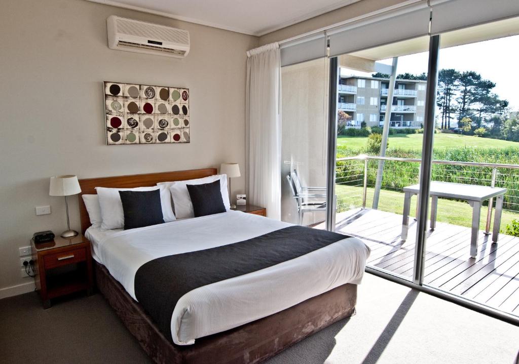 una camera con un grande letto e un balcone di Silverwater Resort Phillip Island a San Remo